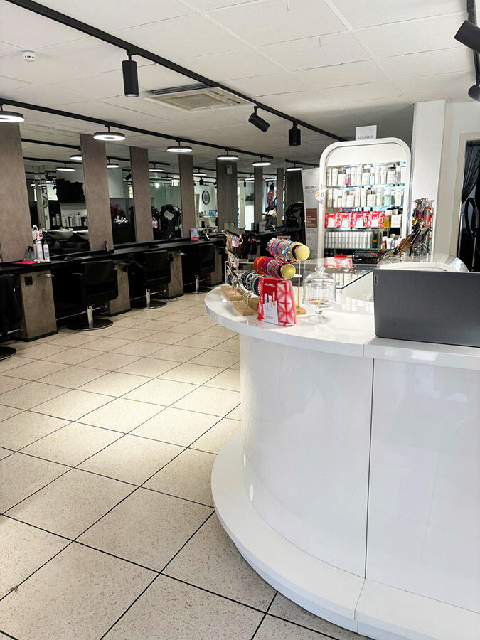 De lichte salon met kappersstoelen en de witte balie